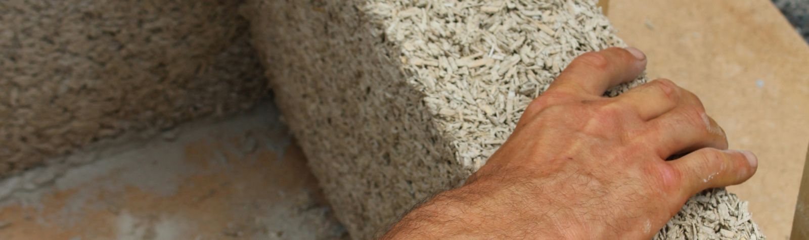Hand resting on a hemp-lime block